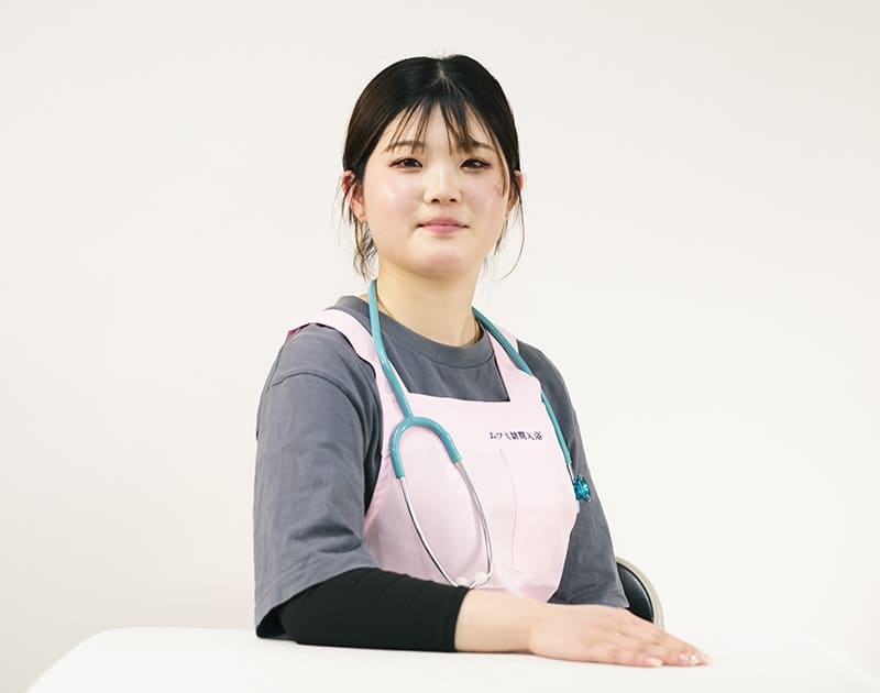 訪問入浴ナースのJ.O.さん。聴診器を掛けたピンクのエプロン姿