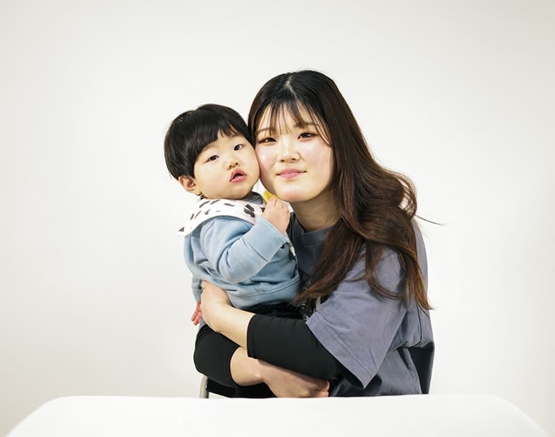 休日のJ.O.さん。小さな子どもを抱いている