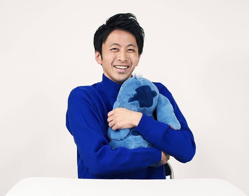 休日のT.T.さん。大きなぬいぐるみを抱えて笑っている